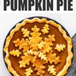 Pumpkin pie topped with leaf-shaped pie crust cookie cutouts to decorate it.