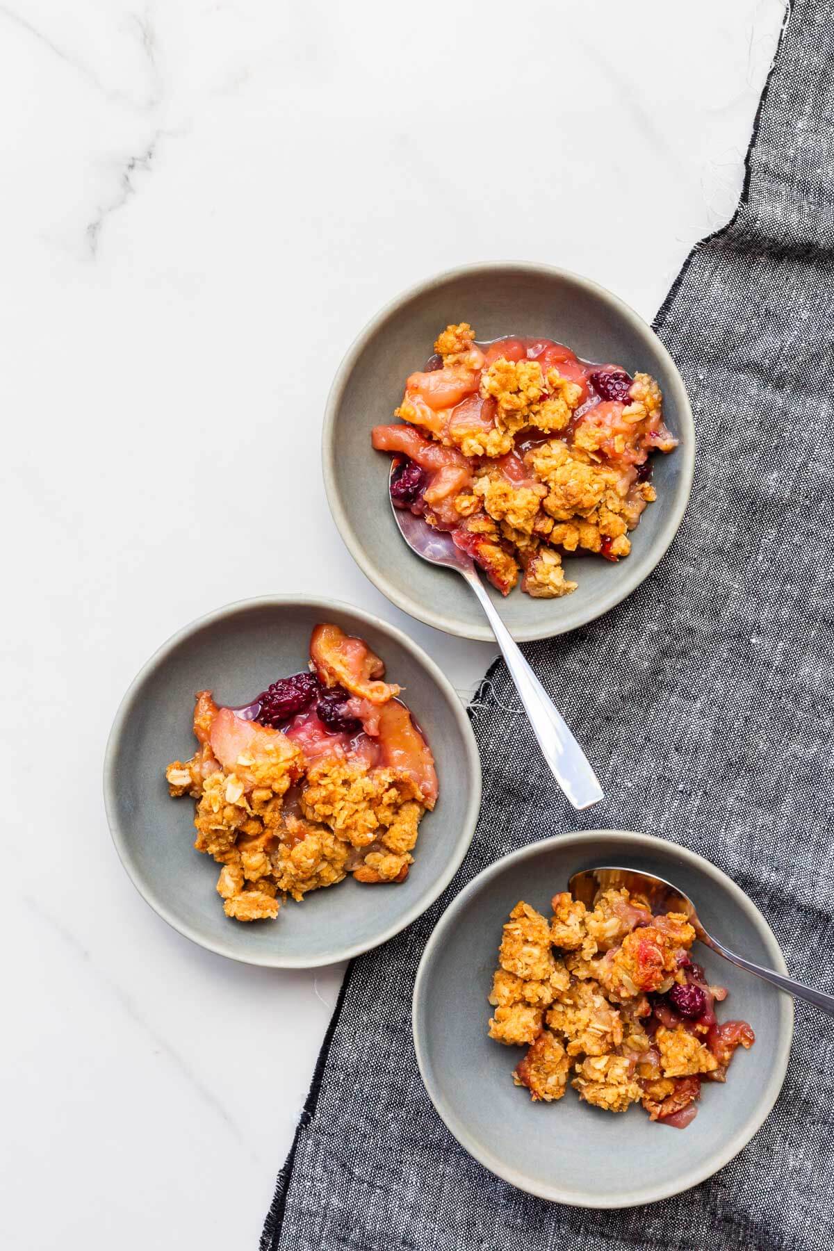 Bowls of apple blackberry crumble with oats.