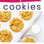 Maple cookies on a sheet pan served with a glass of milk.
