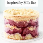 Milk Bar style naked cake featuring layers of almond cake, almond frosting, blackberry lemon curd, and blackberry purée for a stunning purple and creamy beige layer cake