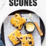 A plate of blueberry scones served with butter.