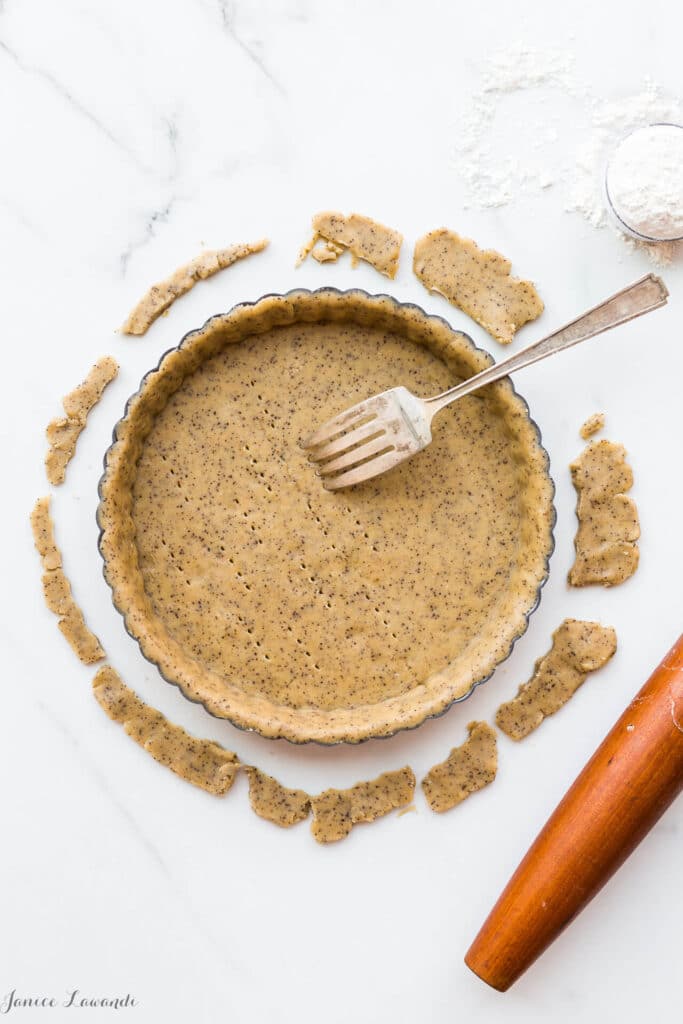 Coffee sablé cookie crust - the raw crust is being docked (pricked) with a fork to allow steam/air to vent during baking. The crust will be blind baked