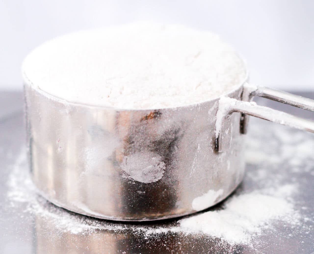 A measuring cup filled with flour.