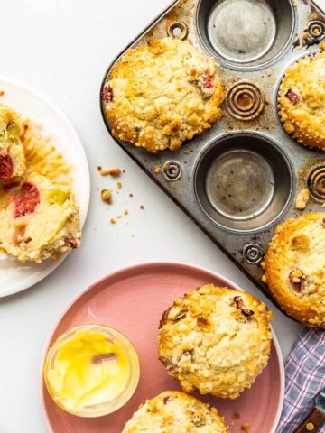 Serving rhubarb muffins on plates with a side of butter.