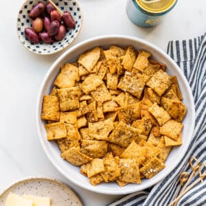 A bowl of homemade crackers served with cheese and charcuterie.