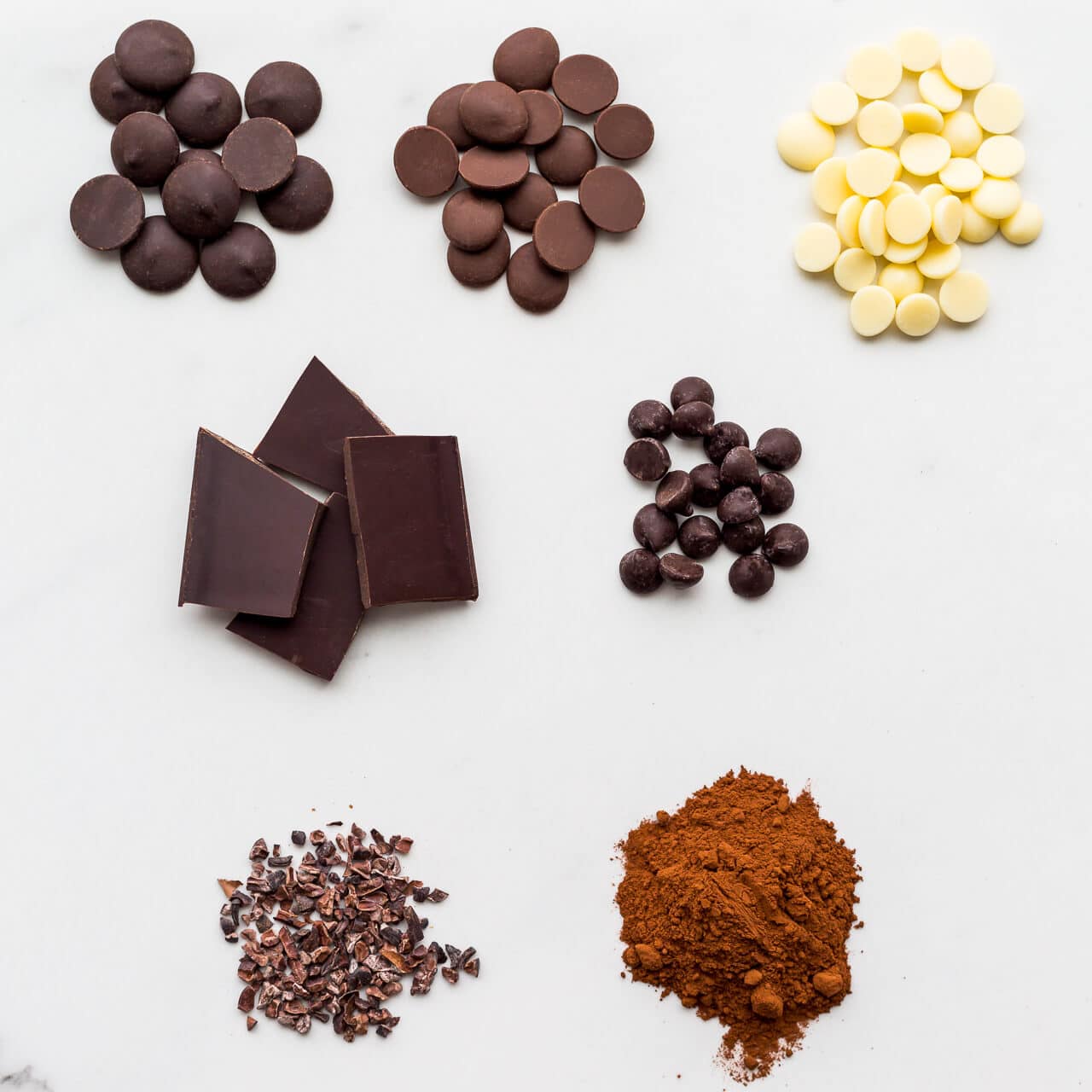 different types of chocolate, dark, milk, and white chocolate, as well as chocolate chips, cocoa nibs, and cocoa powder.